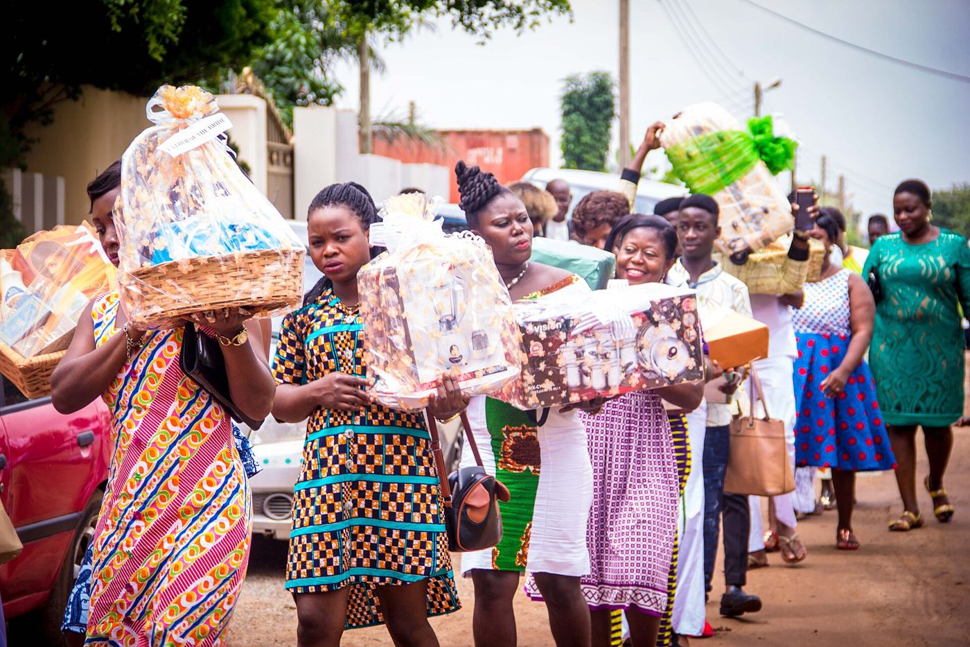 Women in kente carrying gift baskets in an engagement procession