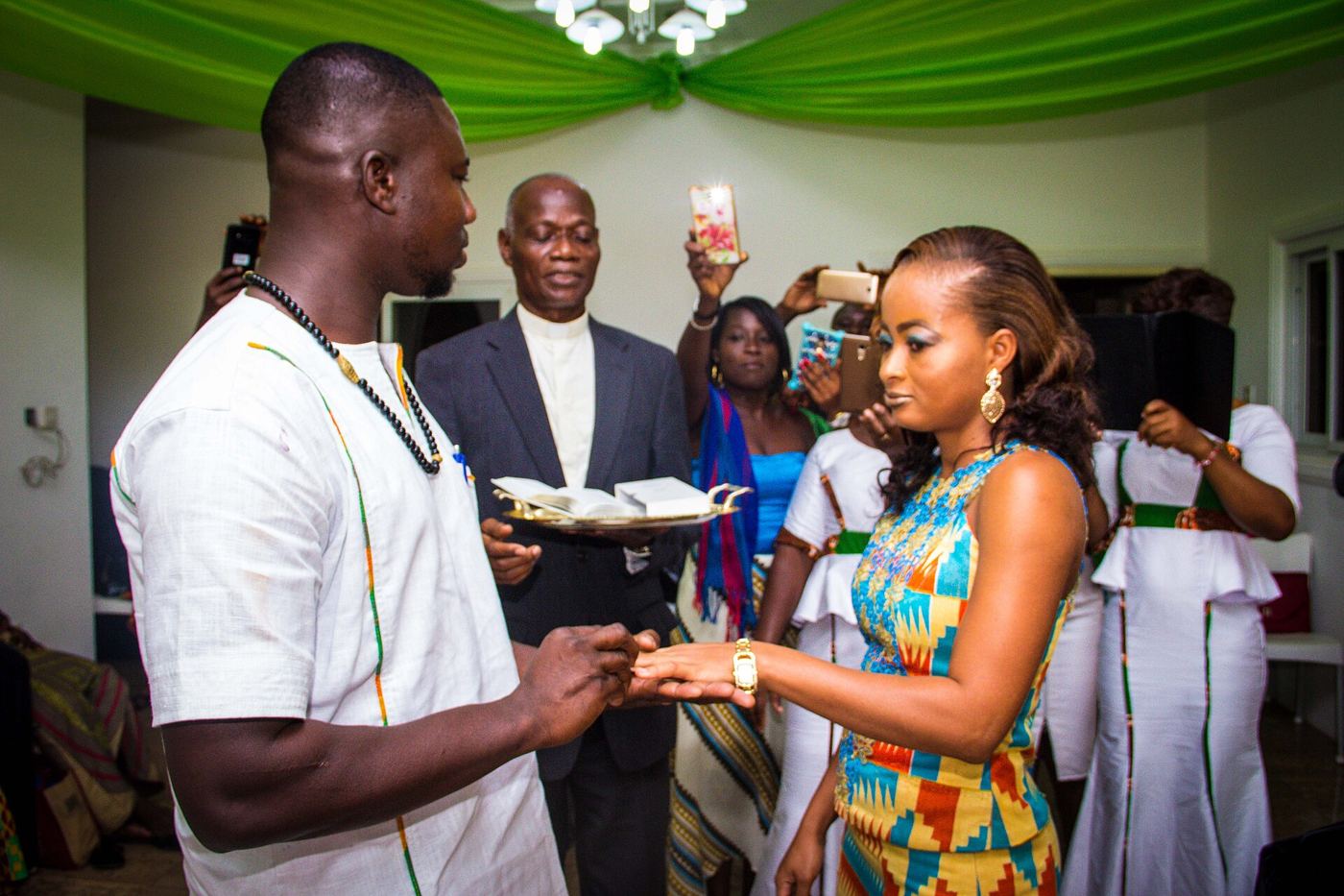 Couple in kente exchanging rings at a Ghanaian engagement ceremony